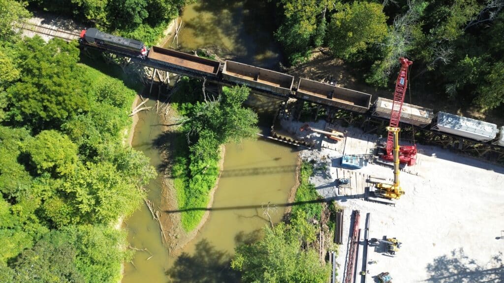 Construction project over a creek in Perry County, Indiana, featuring a train and machinery.