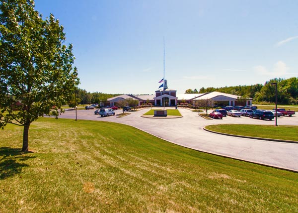 Modern building exterior on a sunny day with green lawns and clear blue skies.