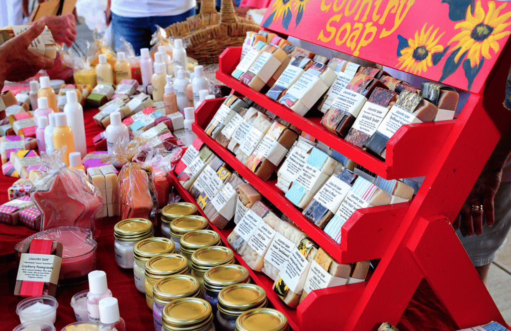 Colorful country soap collection displayed at a market, showcasing various handmade soaps.