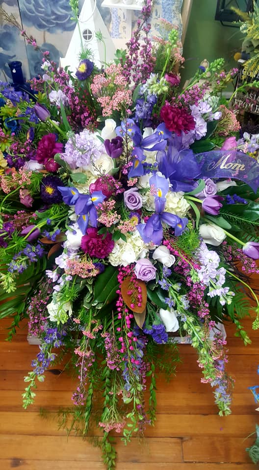 Vibrant flower arrangement featuring irises, roses, and mixed greenery for stunning decor.