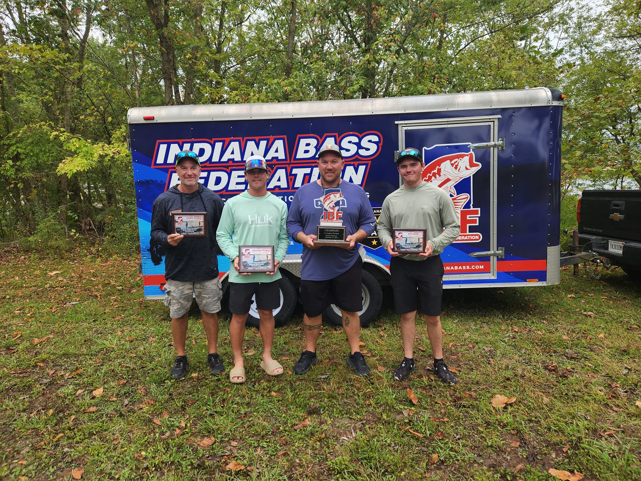 Indiana Bass Federation tournament winners proudly display their trophies by the event trailer.