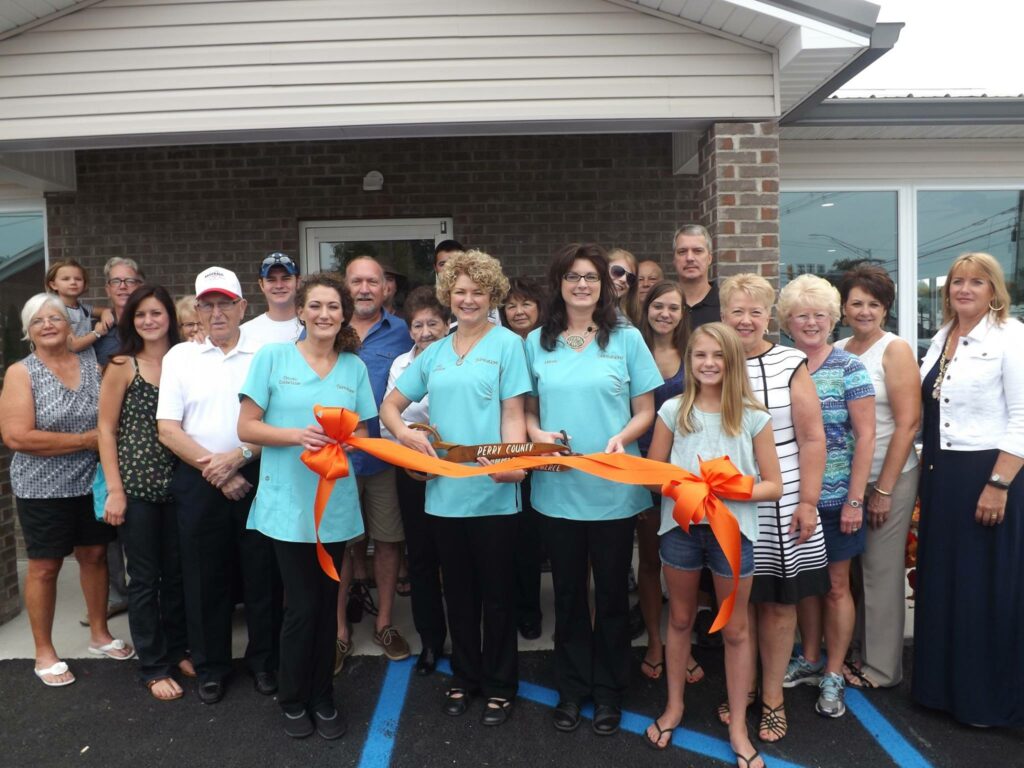 Grand opening celebration with community members at the new location, featuring a ribbon-cutting ceremony.