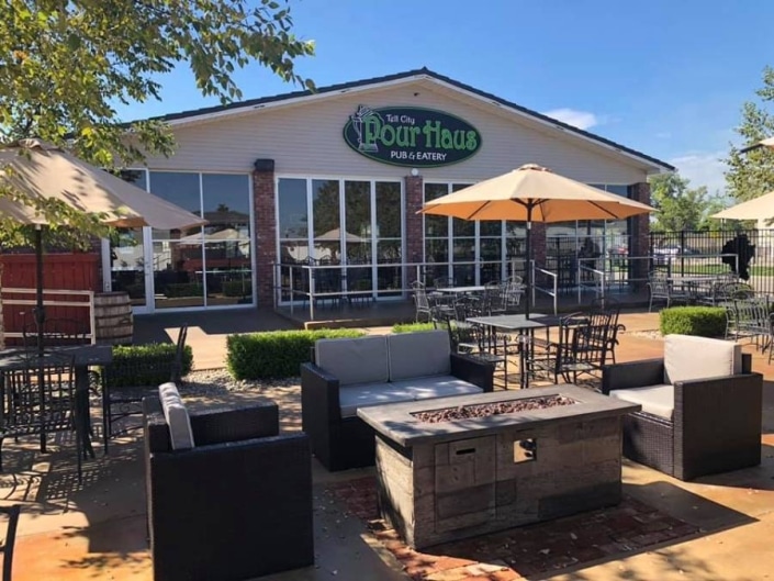Outdoor seating at Pour Haus Pub & Eatery featuring a cozy fire pit.