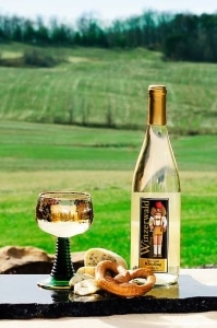 Enjoy white wine paired with snacks in a scenic outdoor setting.