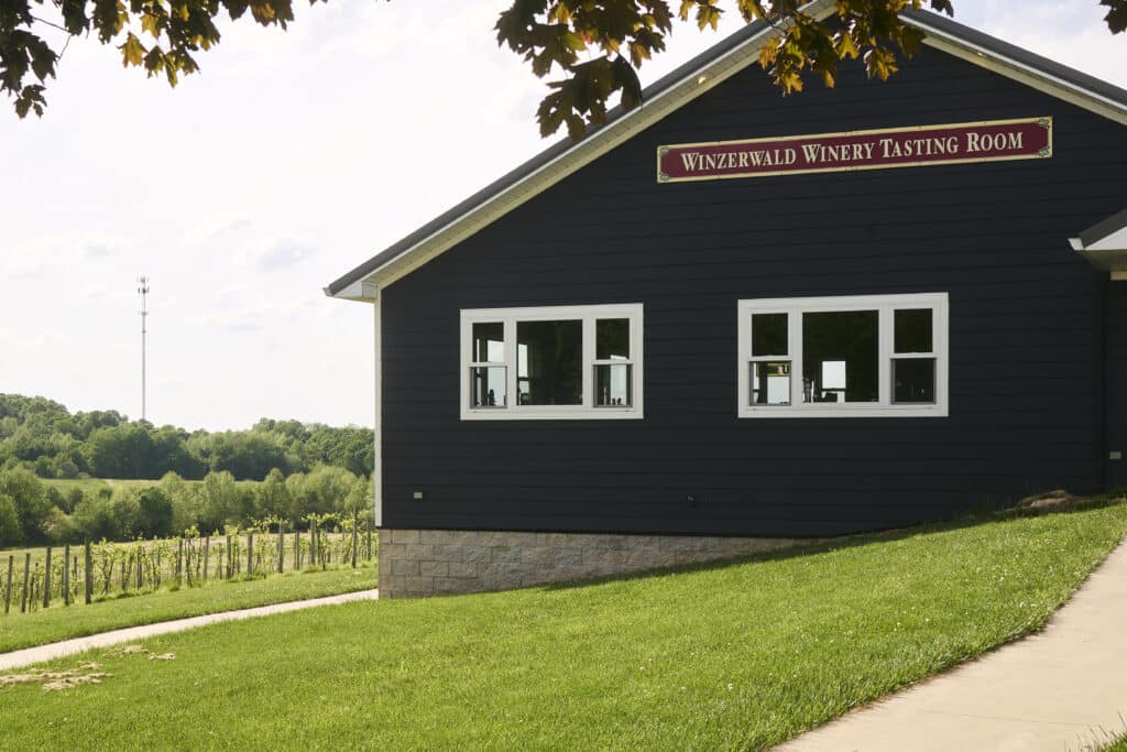 Winzerwald Winery tasting room with lush vineyards in the backdrop.