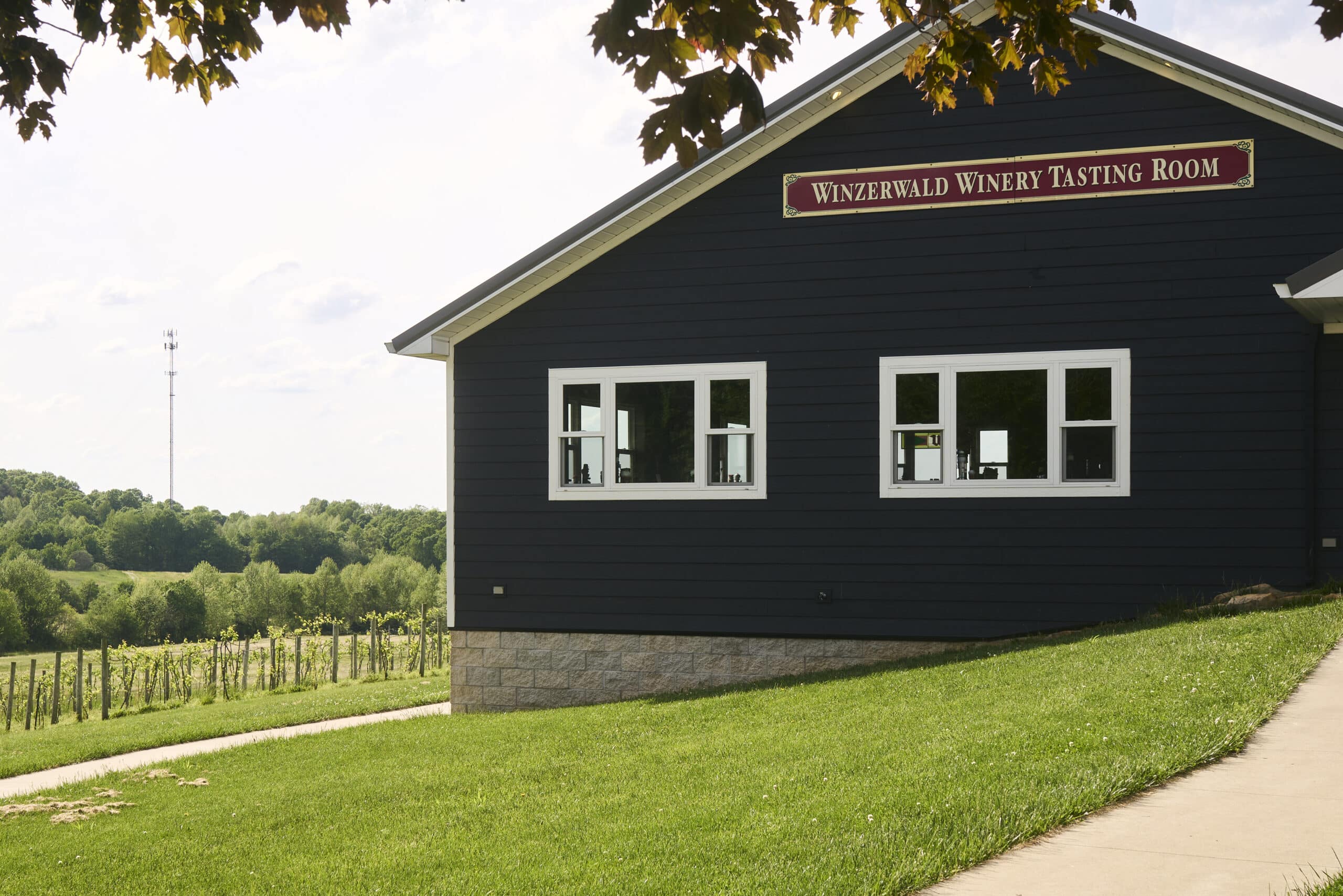 Winzerwald Winery tasting room with lush vineyards in the backdrop.