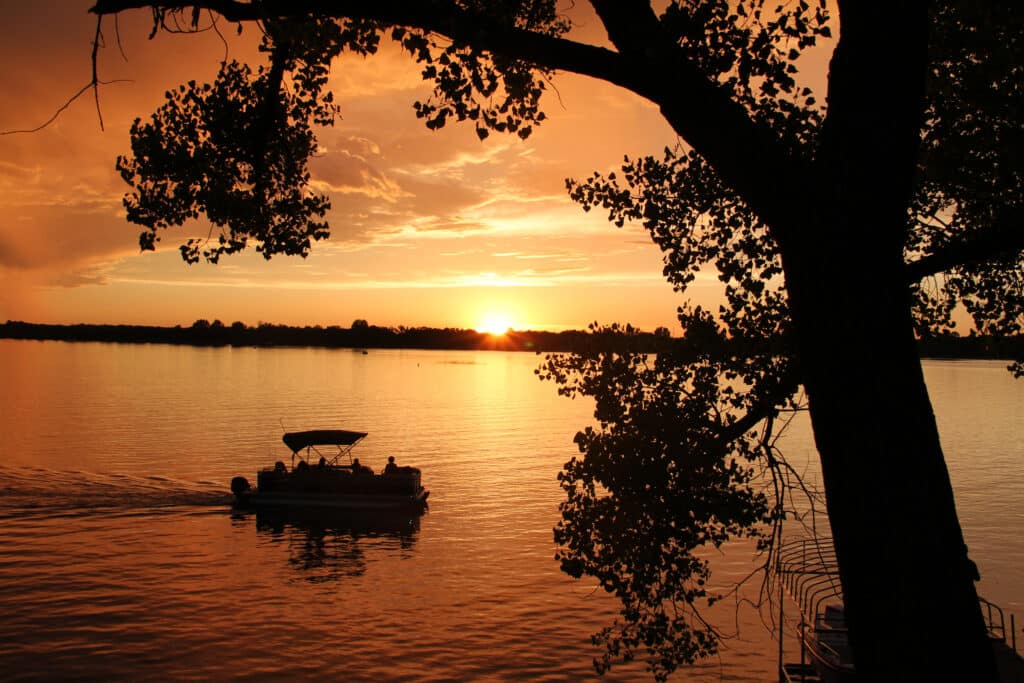 Enjoy a serene sunset pontoon ride on the lake, surrounded by beautiful golden hues.