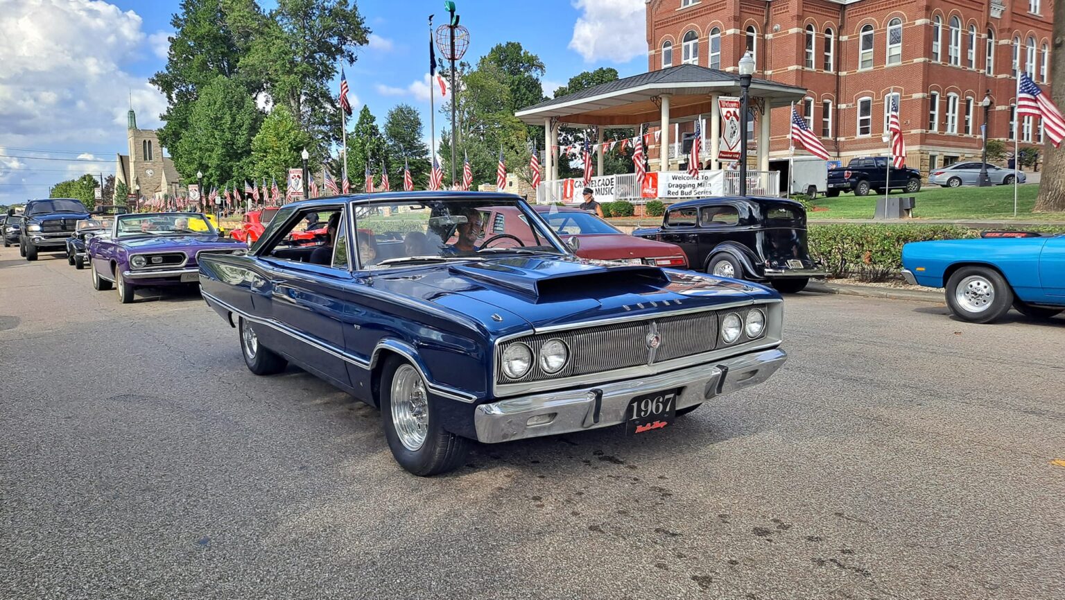 Classic car parade featuring vintage automobiles from 1967 in a lively community event.