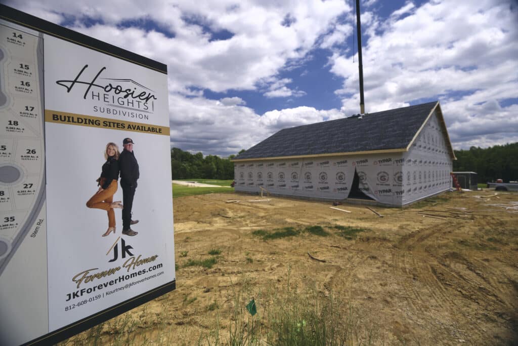 Hoosier Heights subdivision sign showcasing available building sites for new homes.