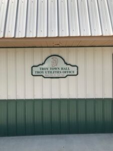 Troy Town Hall Utilities Office sign with hours of operation displayed clearly.