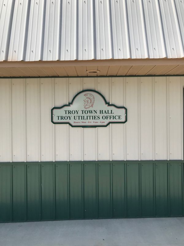 Troy Town Hall Utilities Office sign with hours of operation displayed clearly.