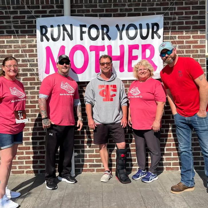 Participants celebrate at the Run For Your Mother event, promoting community and fitness.